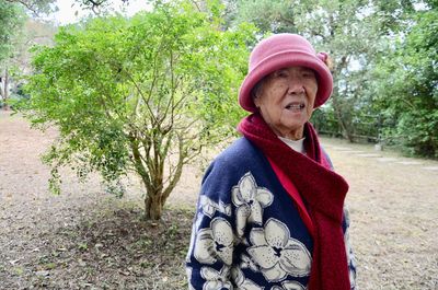 Senior woman wearing warm clothing standing at public park