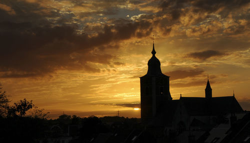 Silhouette of a church seen from the rooftop of the opposite building. summer dusk