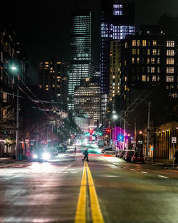 Illuminated city street and buildings at night