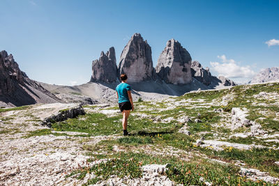 Rear view of a woman looking at  tre cime di lavaredo in the dolomites