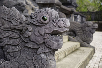 Sculpture dragon heads with stone eyes on the side of the stairs in khai dinh mausoleum