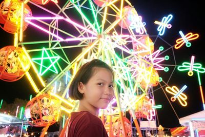 Portrait of smiling girl in amusement park at night