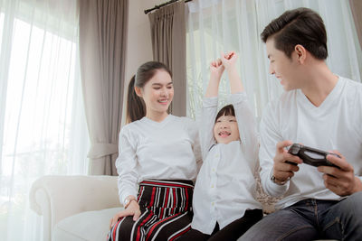 Happy friends sitting in room