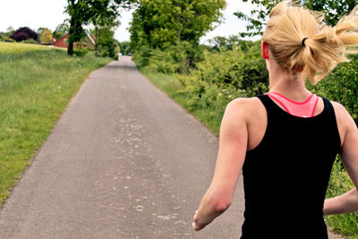 Rear view of a woman jogging on pathway