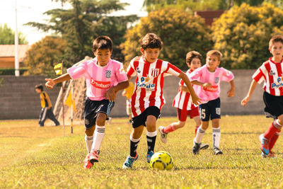 Children playing soccer on field