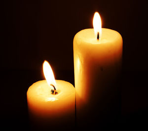 Close-up of lit candles against black background