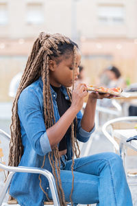 Young woman eating food at cafe