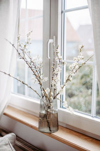 Flower vase on window sill at home