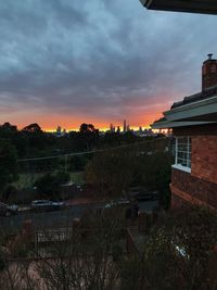 Buildings in town against sky during sunset