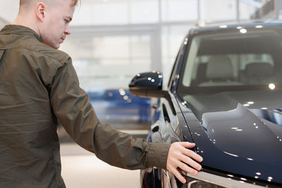 Side view of man holding car