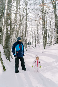 Rear view of man skiing on snow covered field