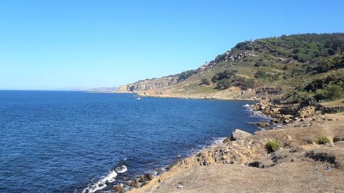 Scenic view of sea against clear blue sky