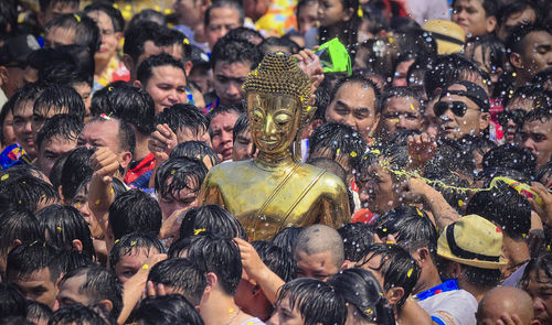Buddha statue amidst people during traditional festival