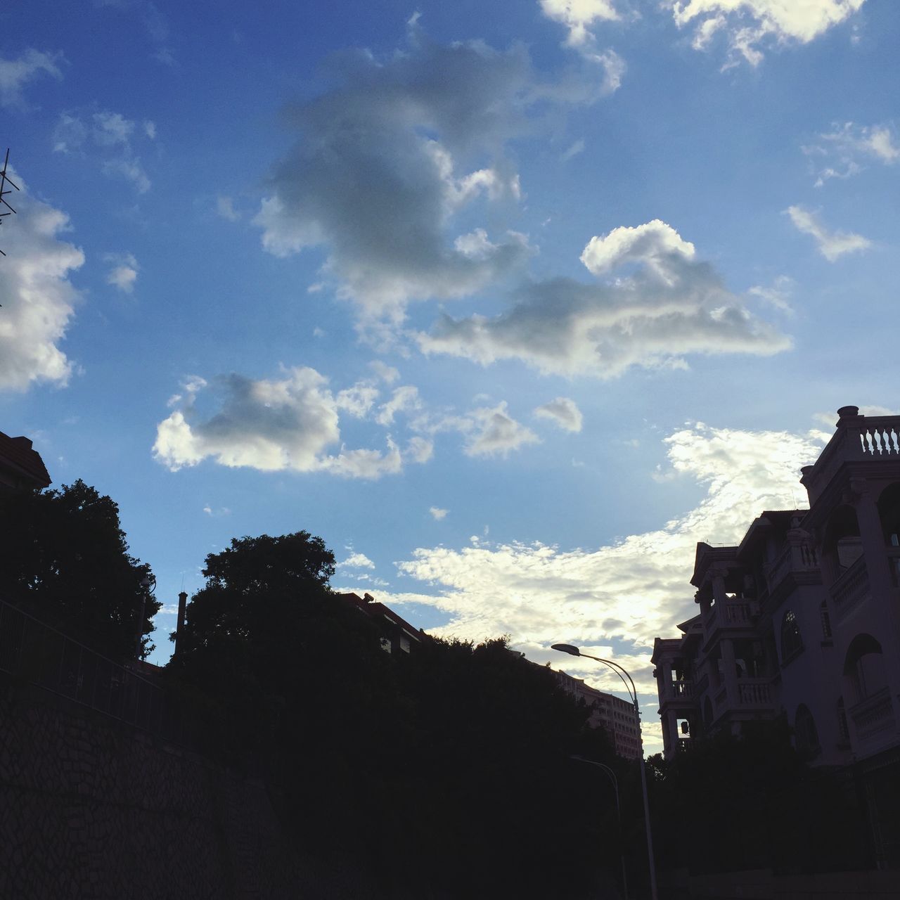 sky, building exterior, silhouette, built structure, cloud - sky, architecture, tree, cloud, blue, low angle view, nature, outdoors, cloudy, house, no people, beauty in nature, sunlight, building, residential structure, day