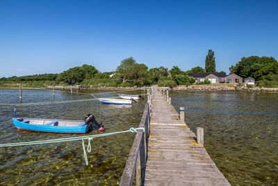 Motorboats by pier on lake