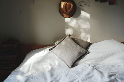 Hat hanging on wall over bed in bedroom