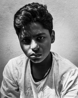 Close-up portrait of teenage boy against wall