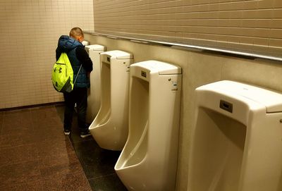 Side view of man standing in bathroom