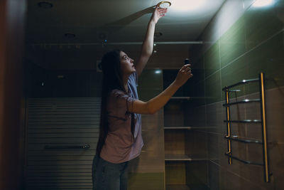 Rear view of woman standing against wall