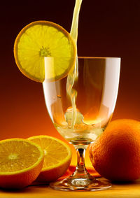 Close-up of drink on table against orange background