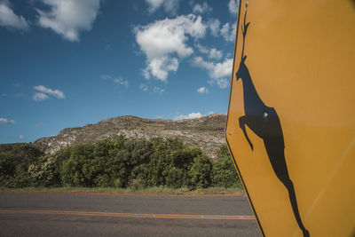 Information sign on road against sky