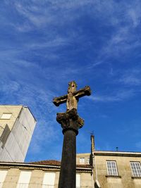 Low angle view of statue against building against sky