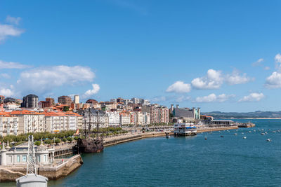 Buildings by sea against sky in city