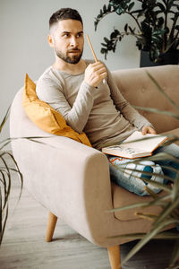 Portrait of boy sitting on sofa at home
