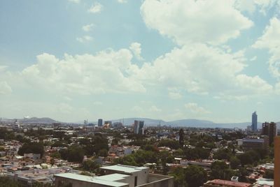 Cityscape against cloudy sky