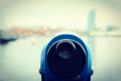 Close-up of coin-operated binoculars against sea