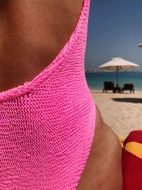 Woman wearing pink textured swimsuit view from behind