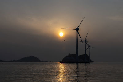 Silhouette of wind turbines at sunset