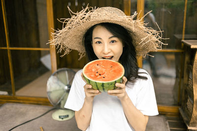 Portrait of smiling young woman sitting at home