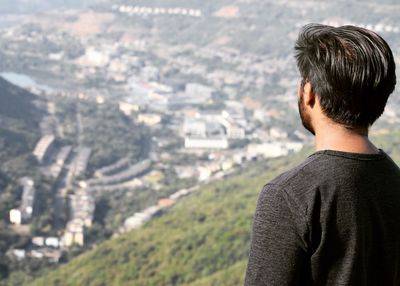 Rear view of man standing against cityscape