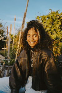 Portrait of smiling young woman sitting outdoors