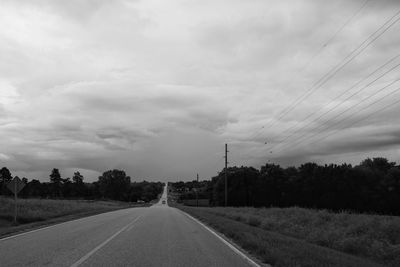 Road by trees against sky