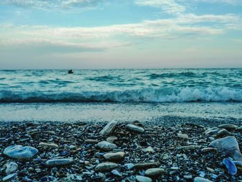 Close-up of pebbles on beach against sky