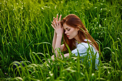 Portrait of young woman sitting on grassy field