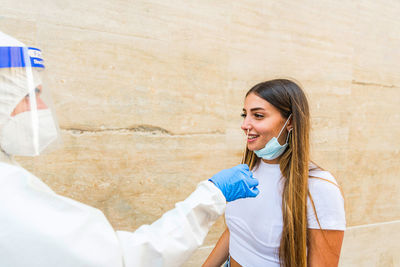 Portrait of smiling couple standing against white wall