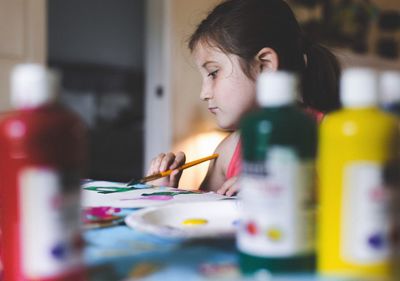 Girl painting on paper at home