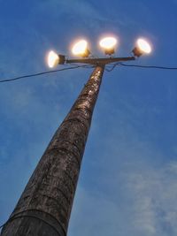 Low angle view of illuminated tower against blue sky