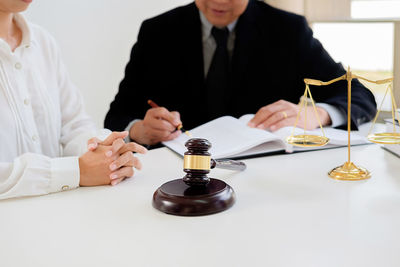 Midsection of judge with woman in courthouse