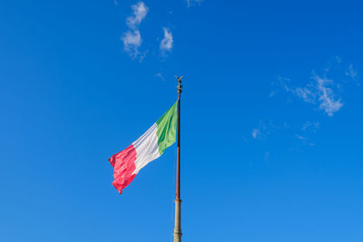 Low angle view of flag flags against blue sky