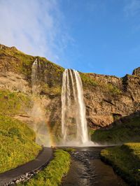 Scenic view of waterfall against sky