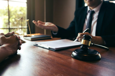 Midsection of people holding cup on table