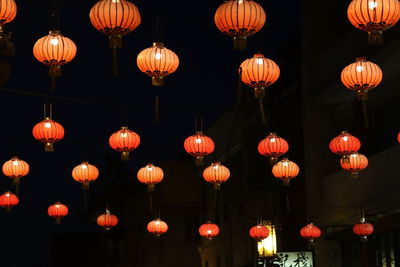 Low angle view of illuminated lanterns hanging at night