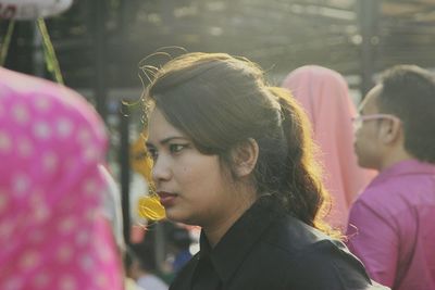 Close-up of thoughtful young woman looking away while standing at market