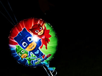 Close-up of illuminated lighting equipment against black background