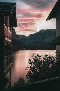 Scenic view of lake by mountains against sky at sunset