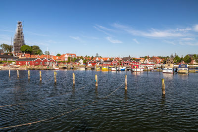 Sailboats in sea against buildings in city